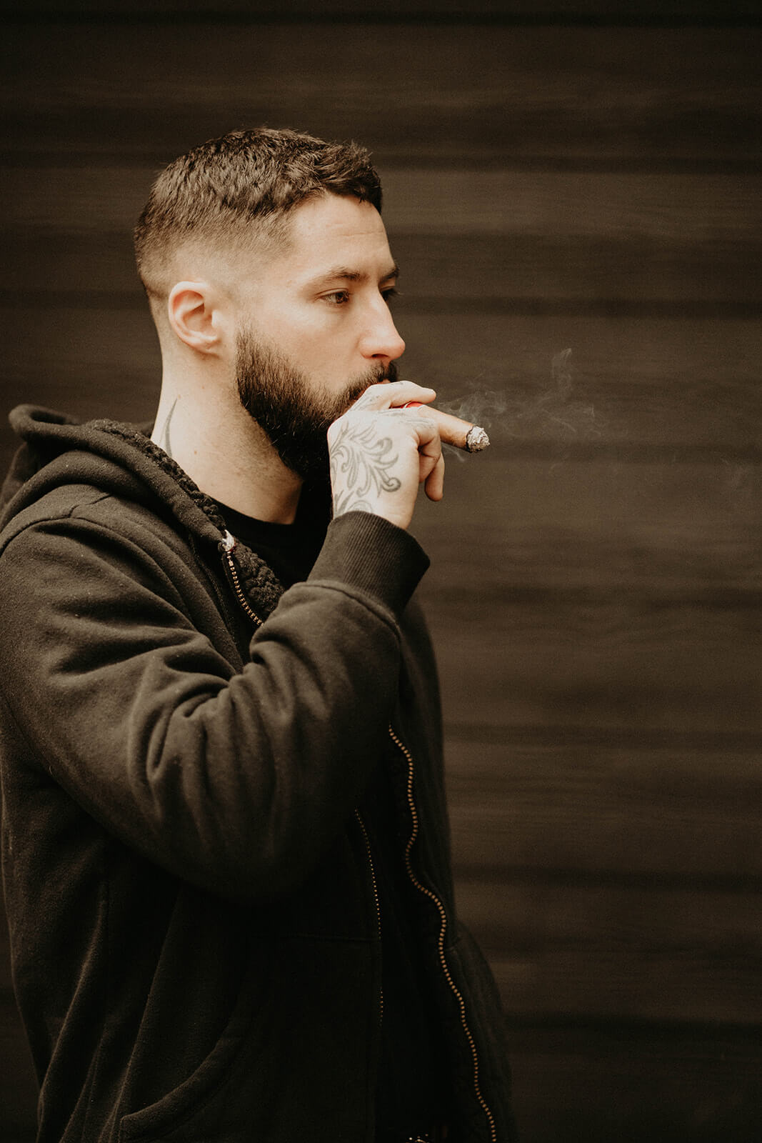 Groom smoking cigar before mount rainier elopement