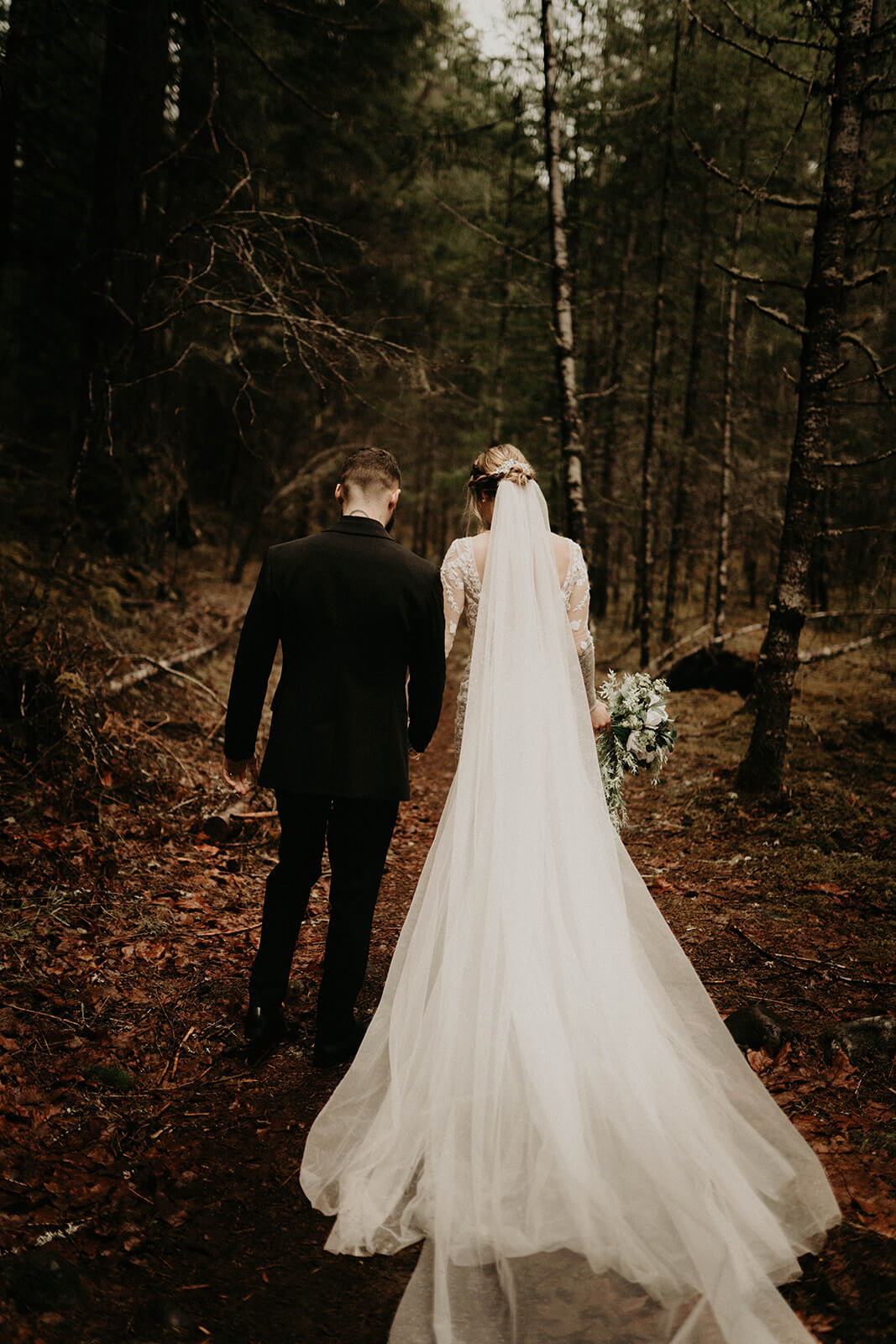 Bride and groom walking through the forest at Mt Rainier elopement 