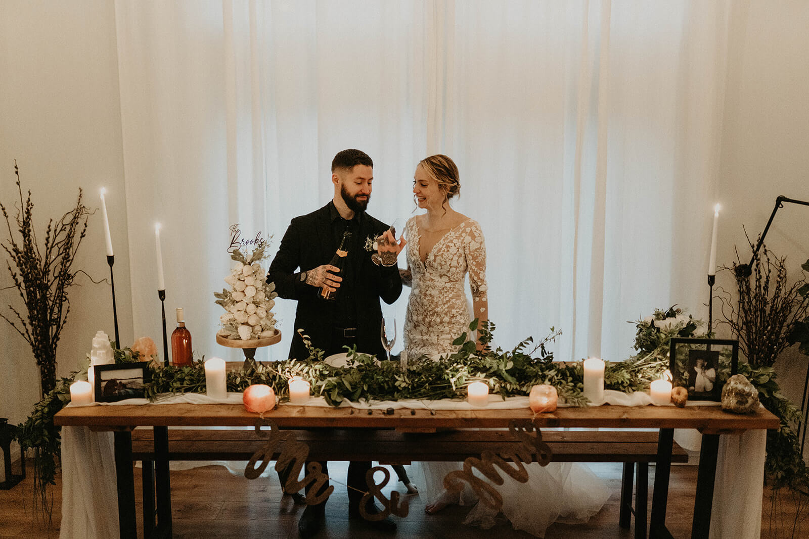 Bride and groom celebrating with champagne in their cozy mountain cabin