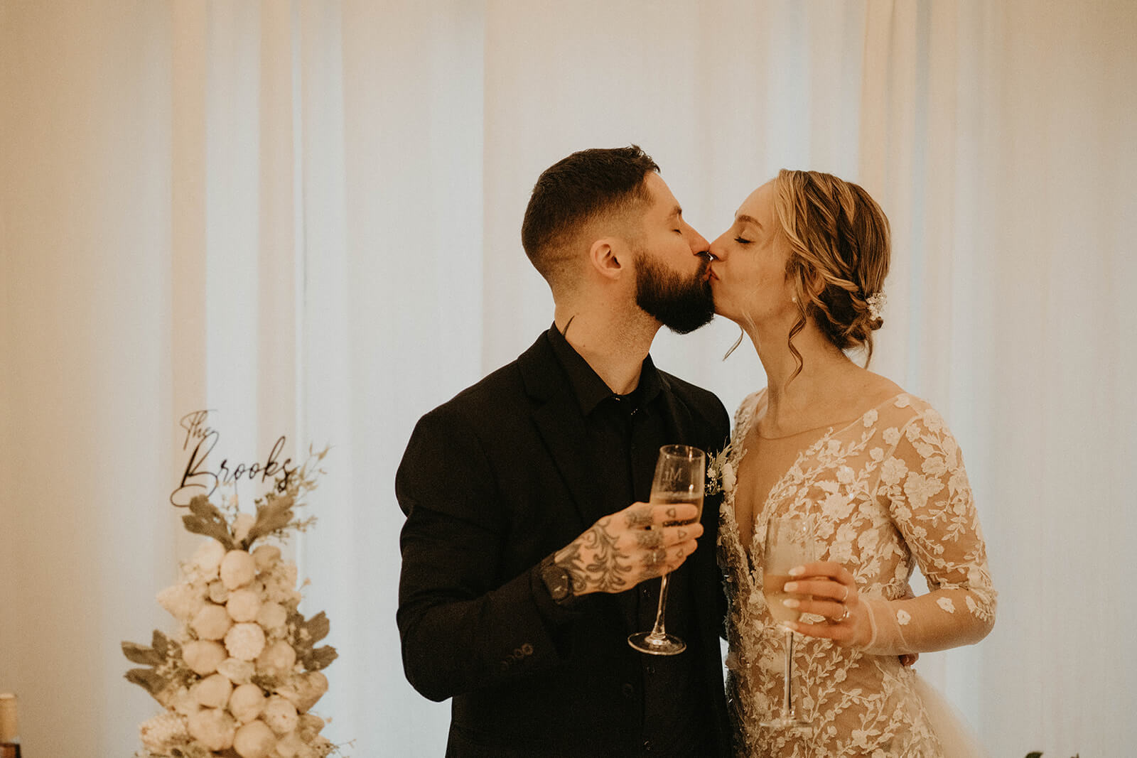 Bride and groom kiss before drinking champagne at Mount Rainier elopement