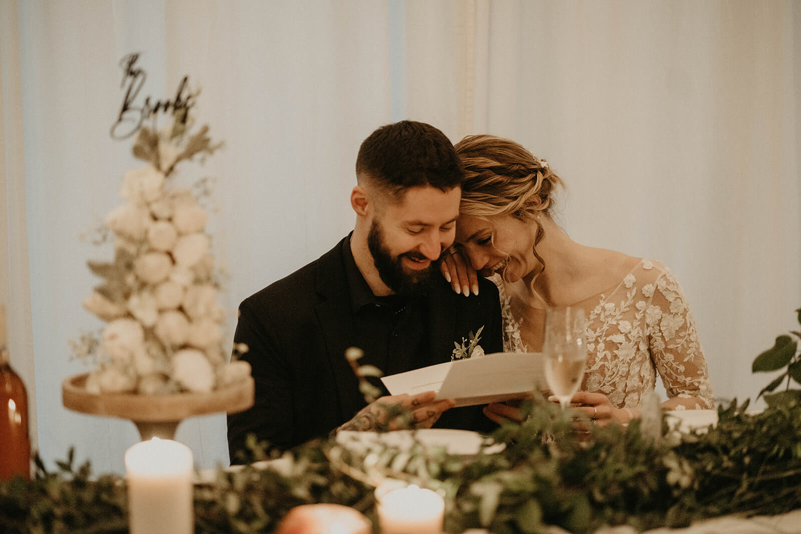 Bride and groom reading letters at the dining table in cozy cabin