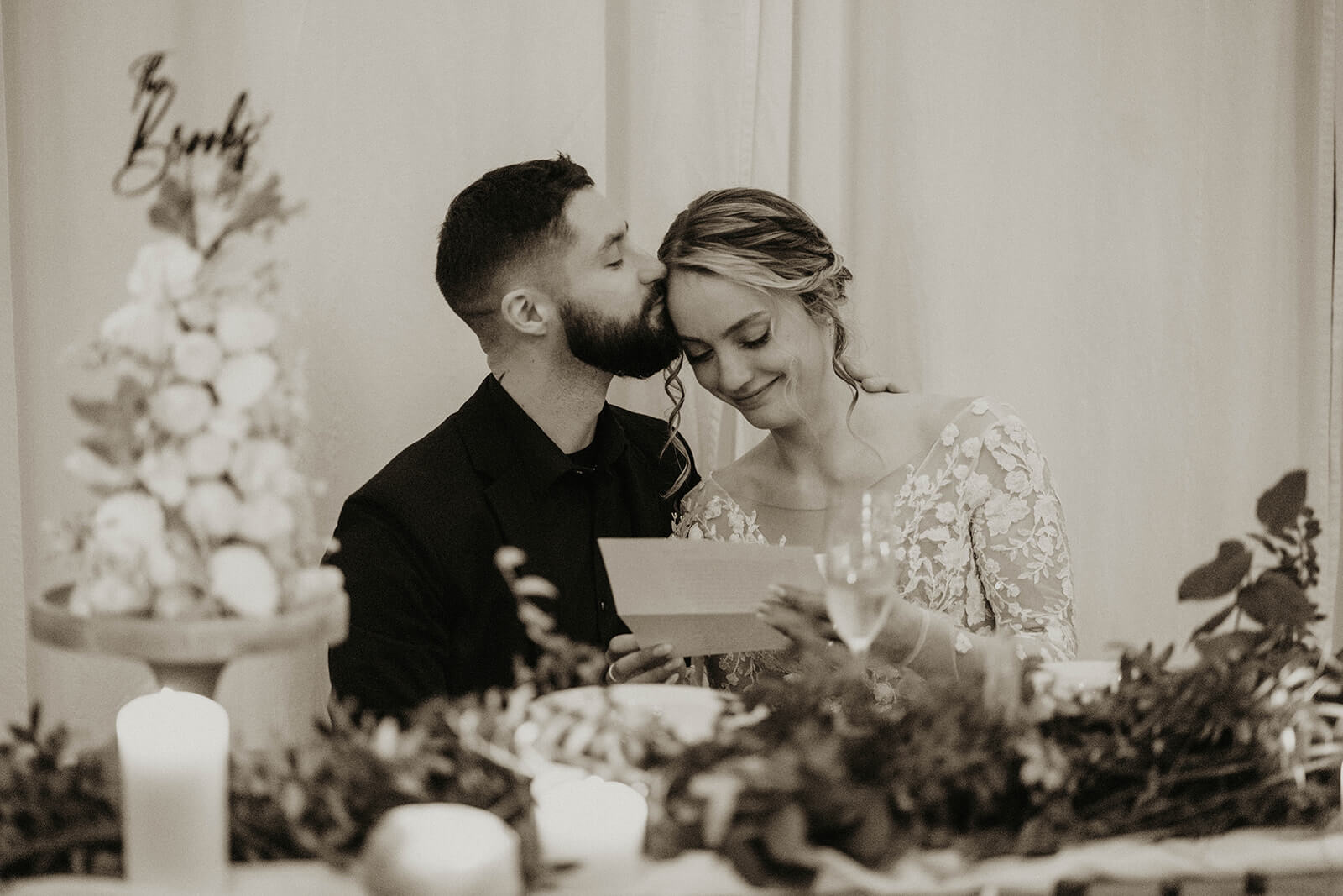 Bride and groom reading letters at the dining table in cozy cabin