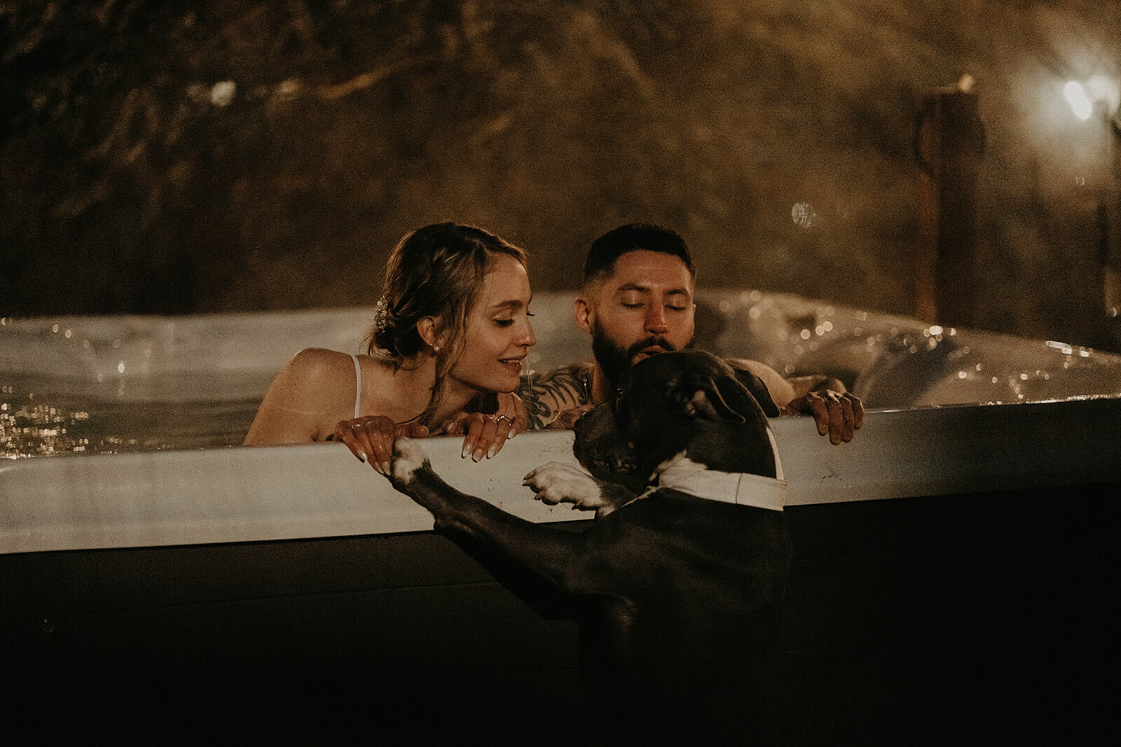 Bride and groom sitting in the hot tub at cozy cabin