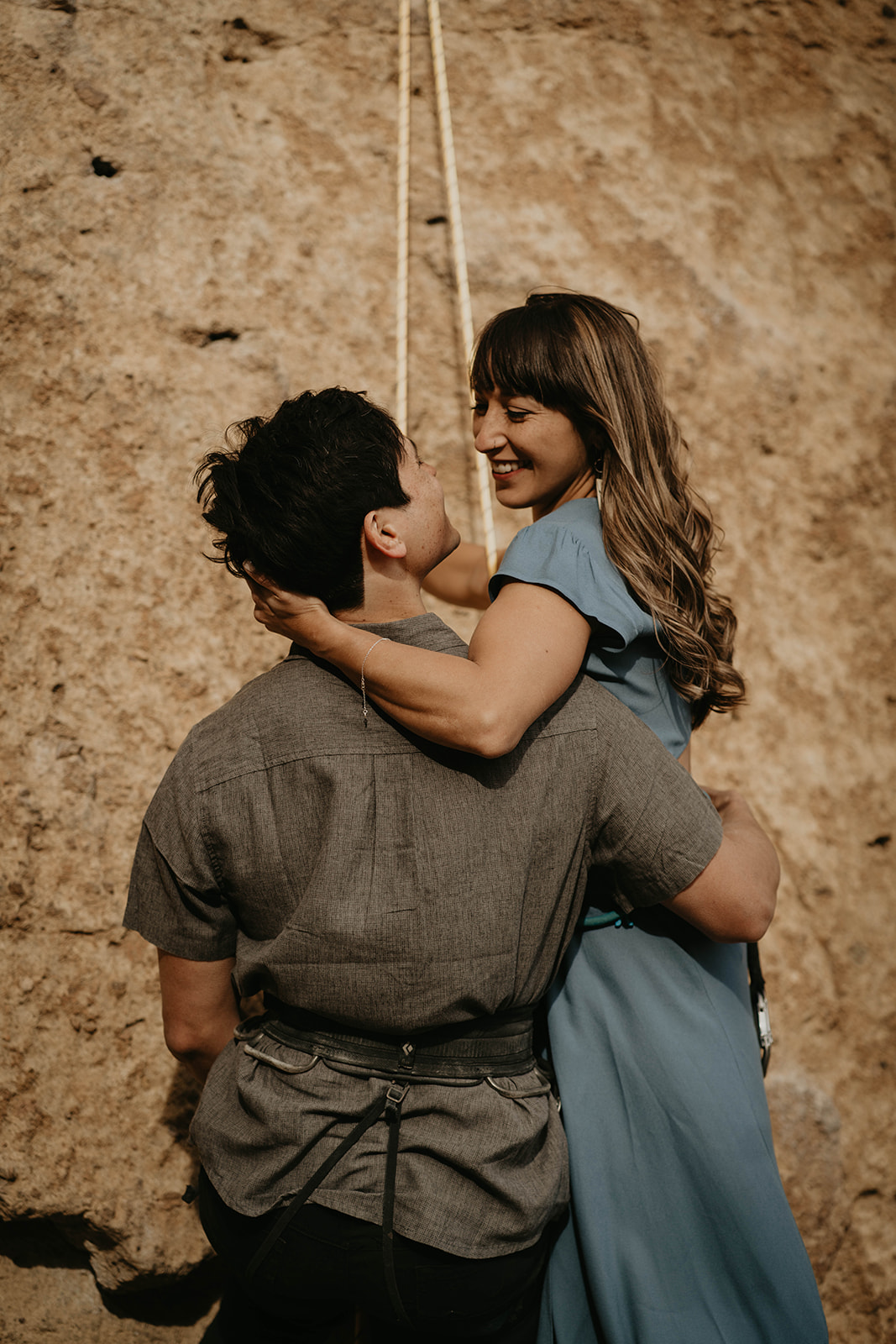 Couple hugging while rock climbing at Smith Rock for engagement session