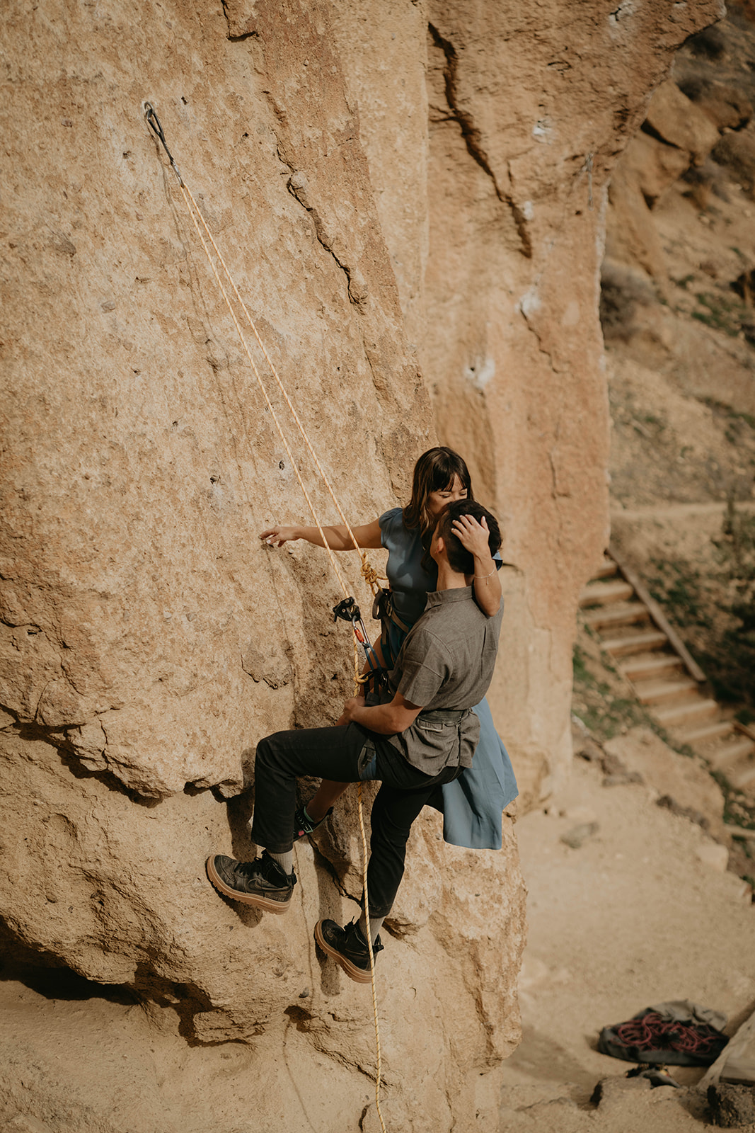 Couple hugging while rock climbing at Smith Rock for engagement session