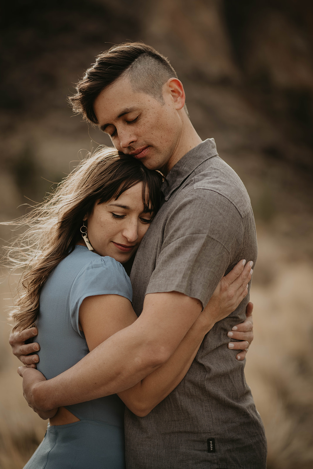 Couple hugging during rocking climbing engagement session at Smith Rock