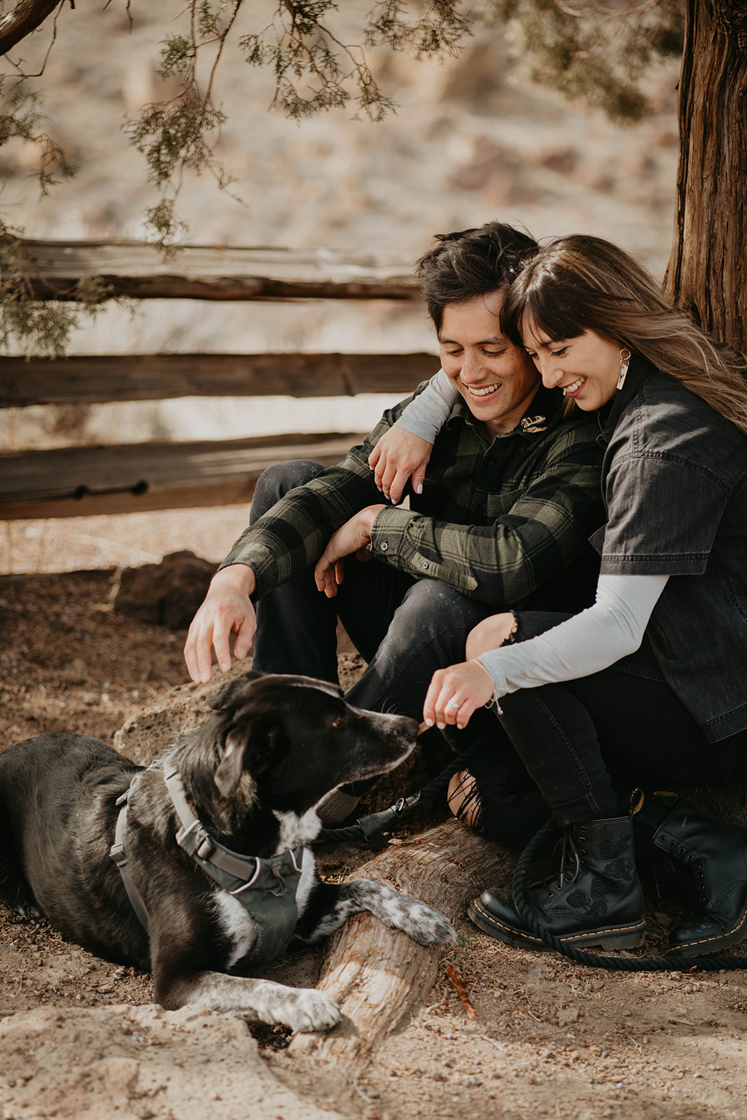 Couple sitting and hugging at rock climbing engagement session