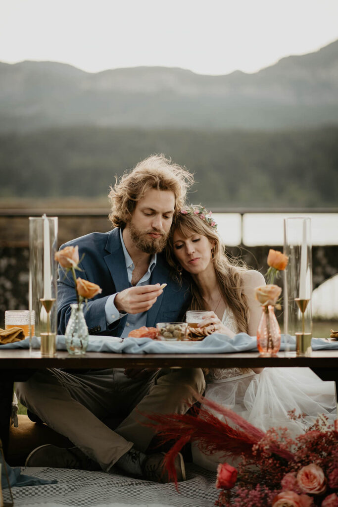 Bride and groom eating during outdoor reception on Thunder Island