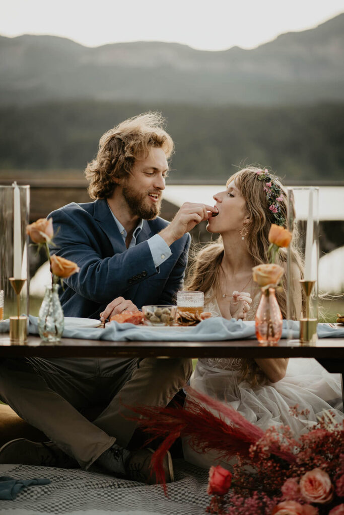 Groom feeding bride during elopement styled shoot reception