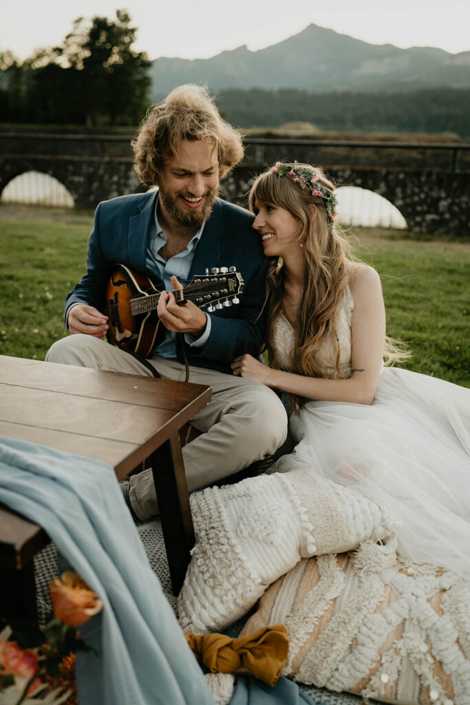 Groom playing guitar for bride during elopement styled shoot on Thunder Island