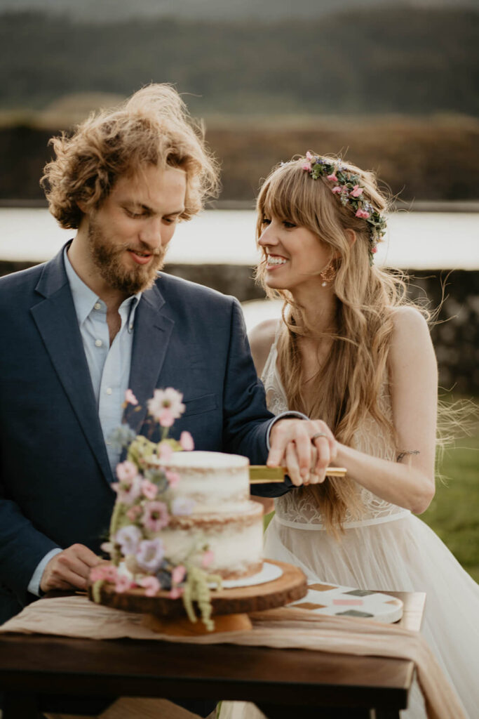 Bride and groom cut cake during outdoor styled wedding shoot