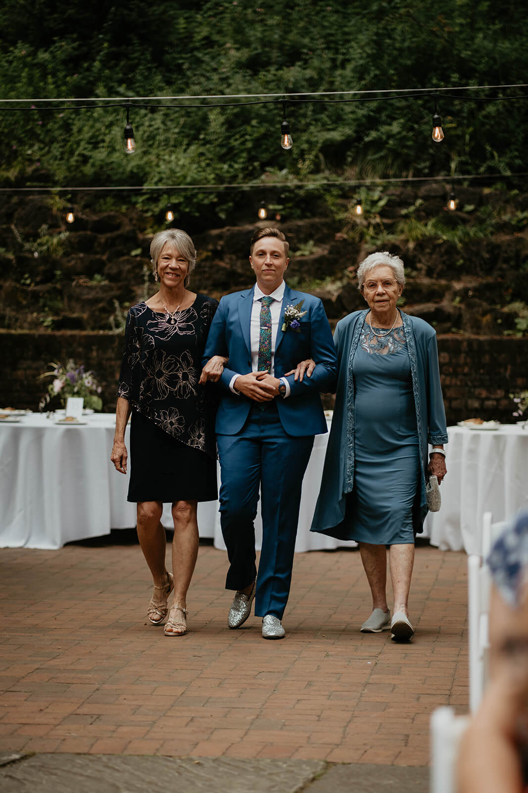 Bride walking down the wedding aisle with mom and grandma