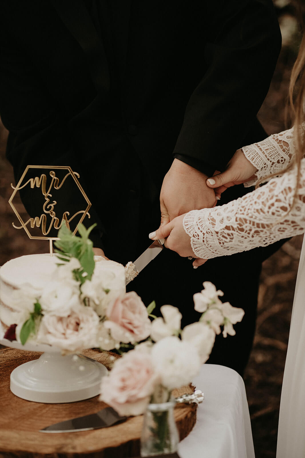 Bride and groom cut cake at forest wedding