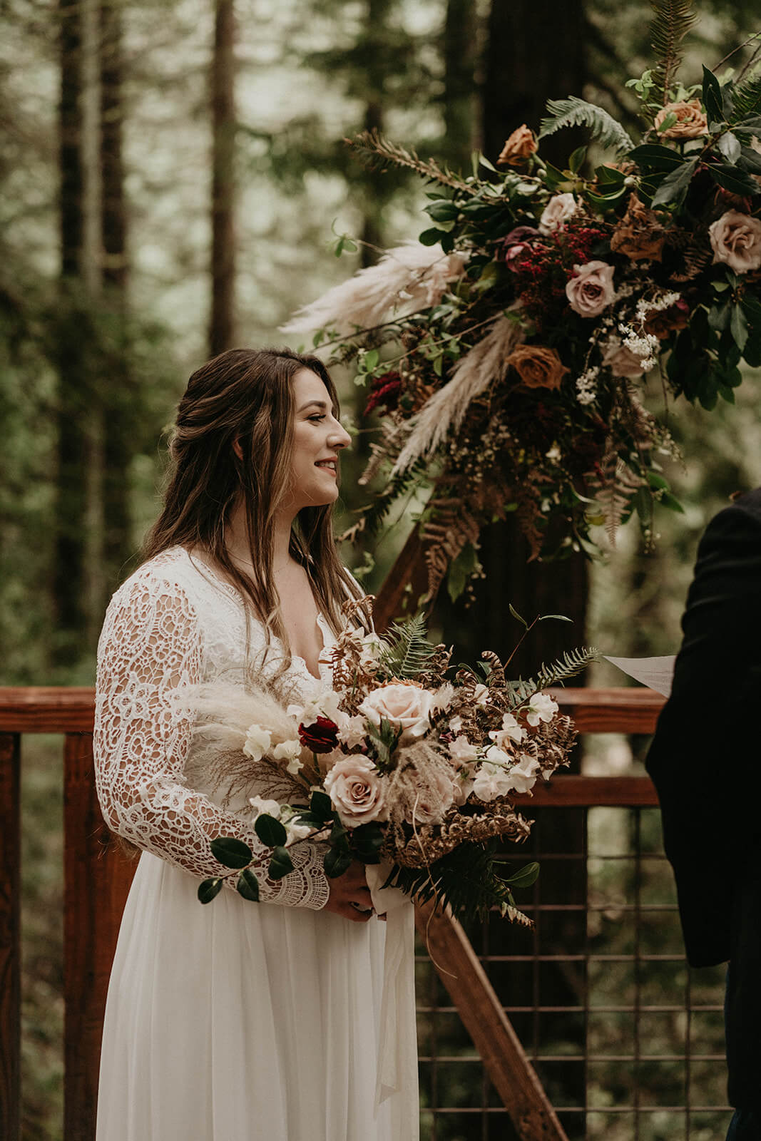 Bride holding pink and burgundy floral bouquet