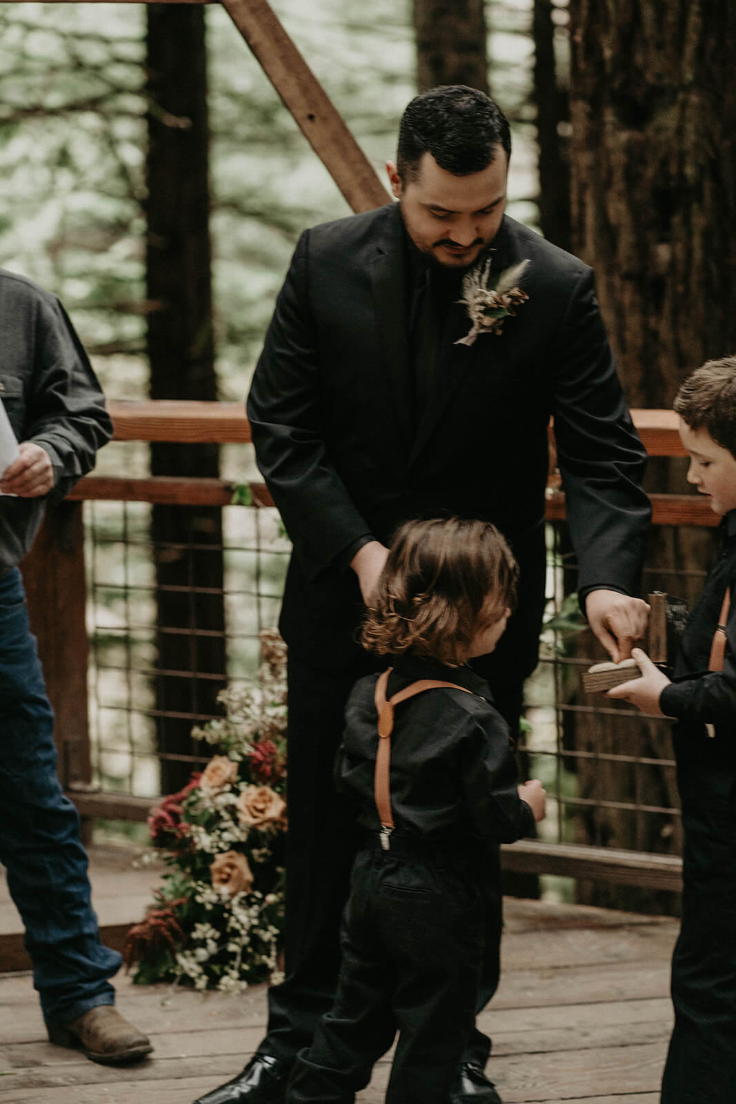 Groom taking ring from ring bearer boy