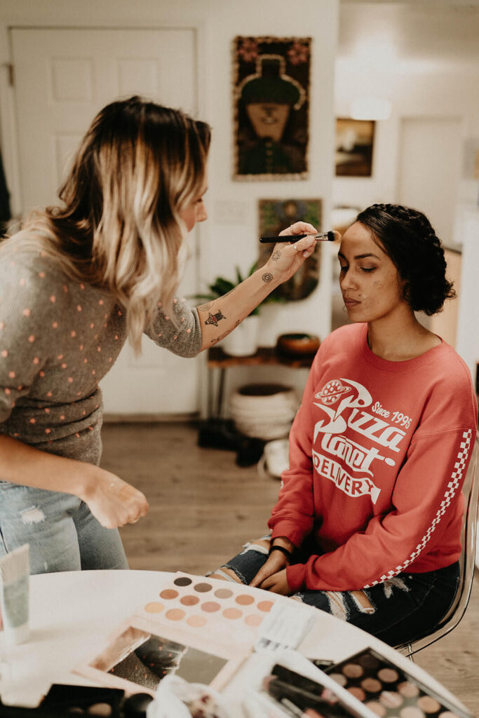 Makeup artist helping bride get ready for Oregon elopement