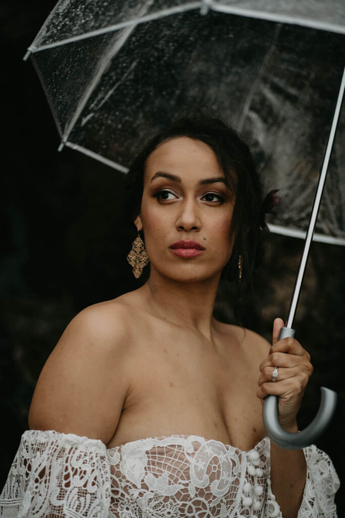 Bride holding clear umbrella during Oregon coast elopement