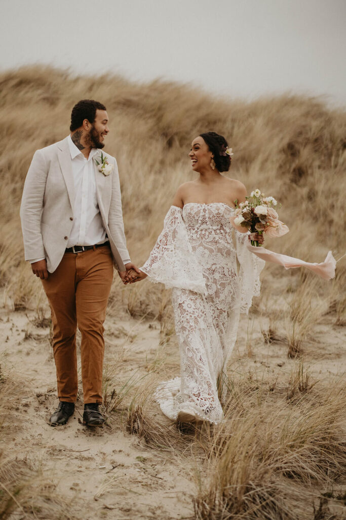 Bride and groom walking hand in hand on the Oregon coast