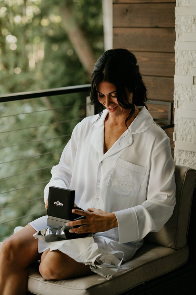 the wife looking at a gift his groom got him. 