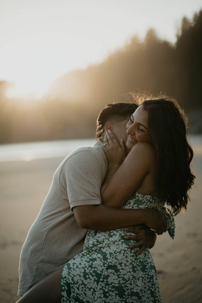 Two women laughing and kissing on the Oregon Coast beach