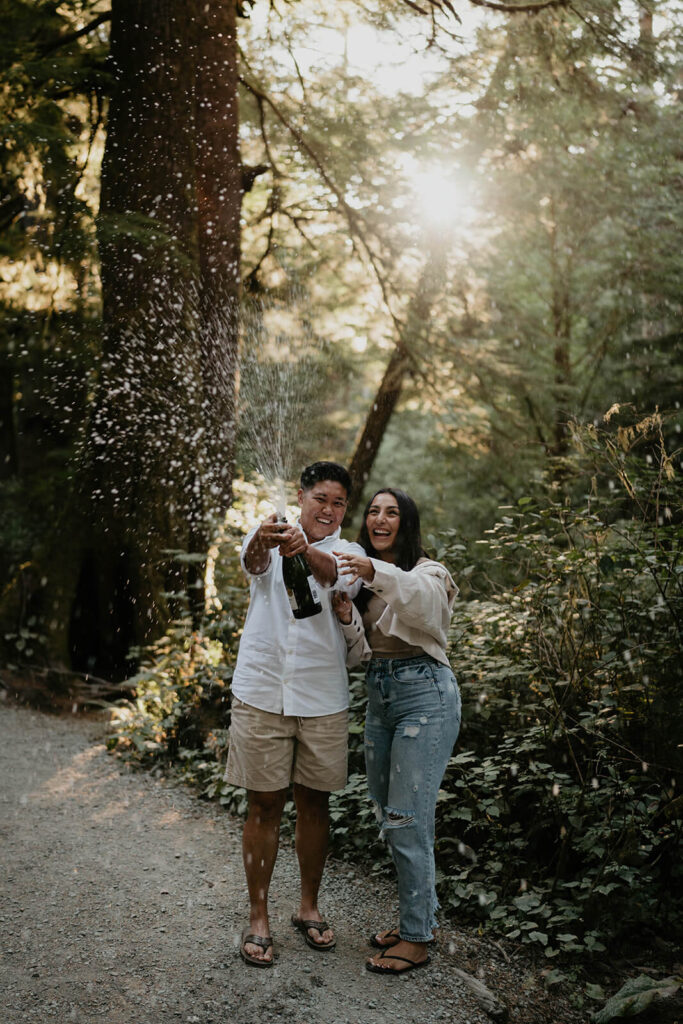 Two women spraying a bottle of champagne during Oregon engagement photos