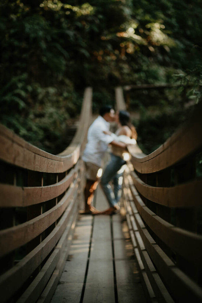 Two women kissing on a suspension bridge on the Oregon coast