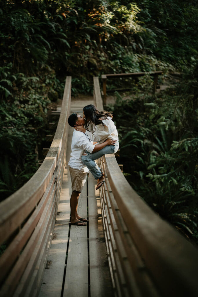 Two women kissing on a suspension bridge on the Oregon coast