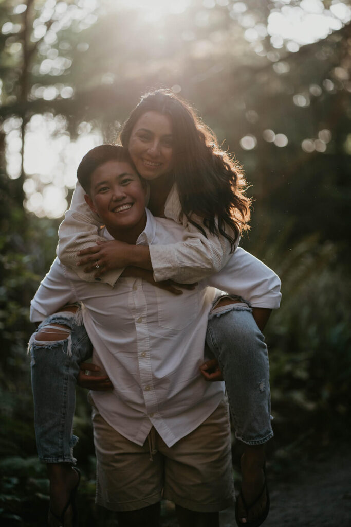 Couple riding piggy back during Oregon coast engagement photos