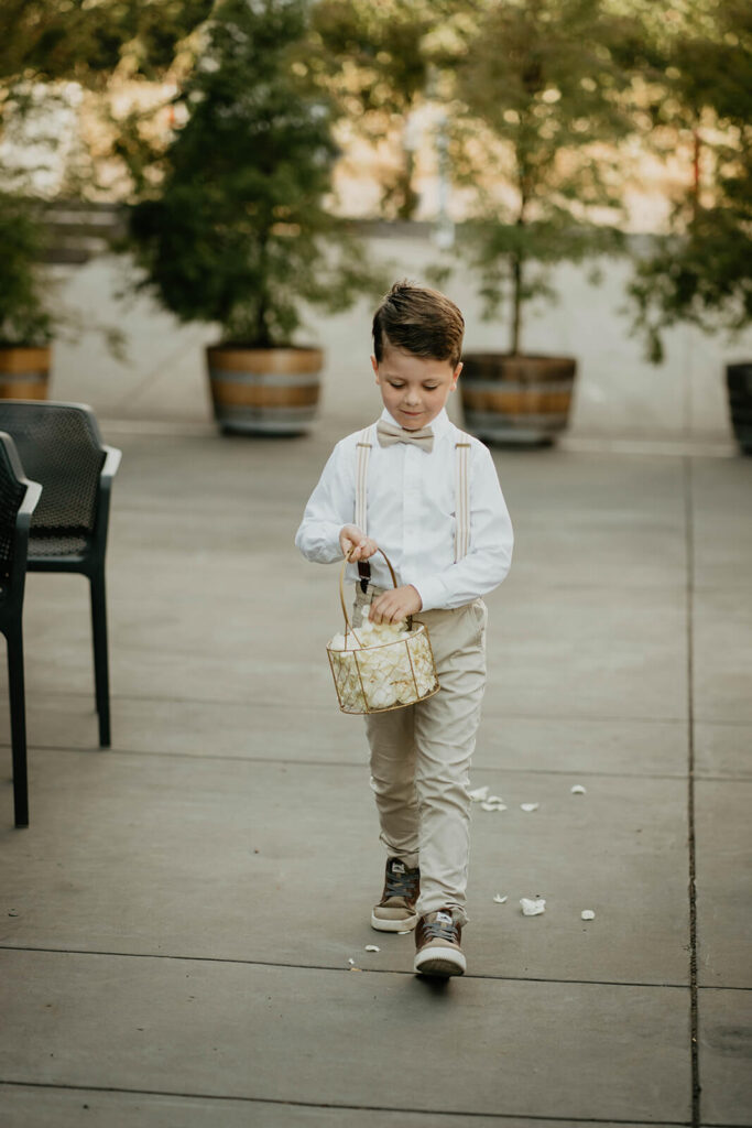 Flower boy dropping petals at Oregon vineyard wedding