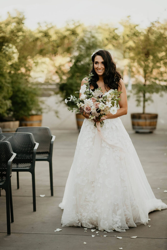 Bride walking down the aisle at outdoor vineyard wedding