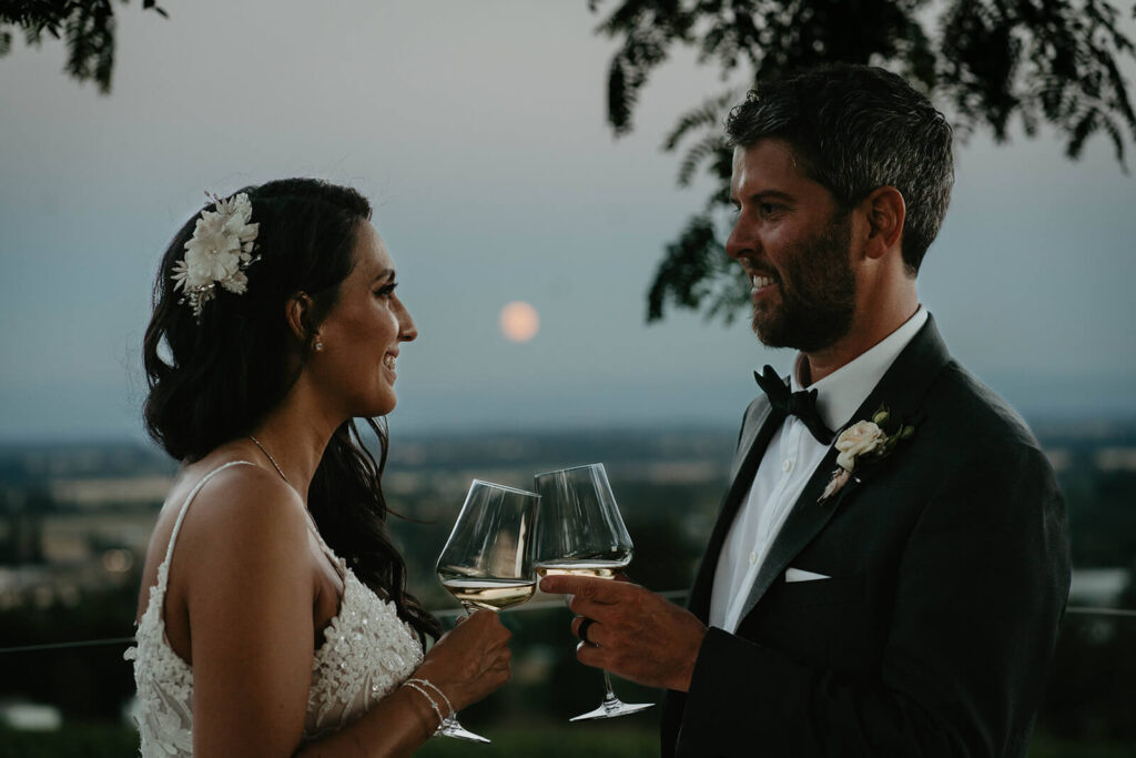 Bride and groom toasting with wine glasses at Oregon vineyard wedding