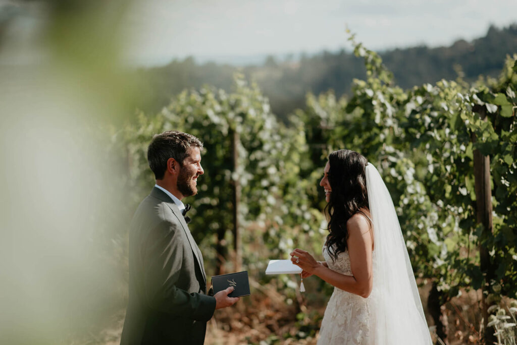 Bride and groom exchange private vows in the vineyard at Oregon intimate wedding