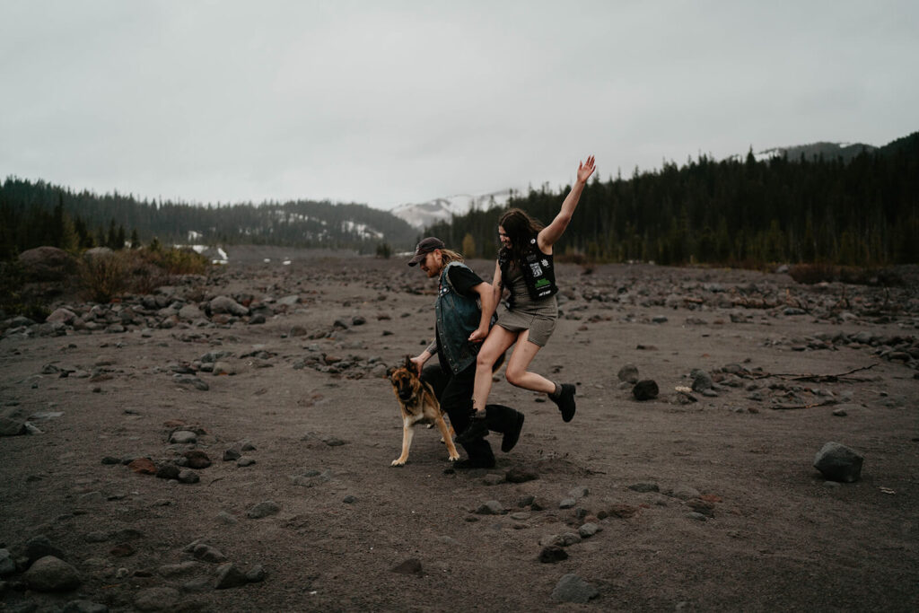 Couple and dog running across the field at Mt Hood