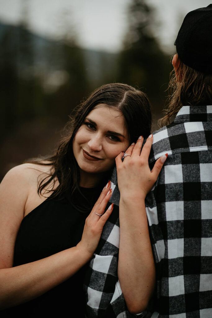 Woman resting hands on man's shoulder during unique engagement photos at Mt Hood