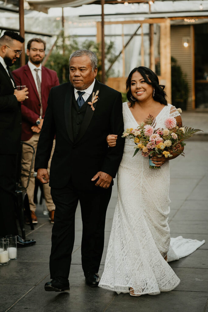 Bride and father walking down the aisle at botanical wedding at Pomarius Nursery