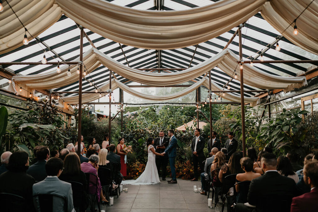 Bride and groom exchange vows at Blockhouse wedding at Pomarius Nursery