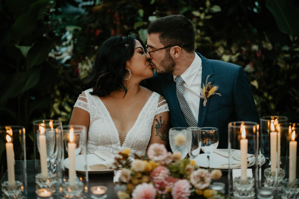 Bride and groom kiss during dinner reception at Blockhouse wedding