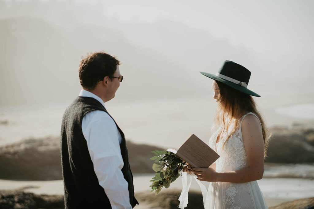 Bride and groom exchange vows during intimate beach wedding ceremony