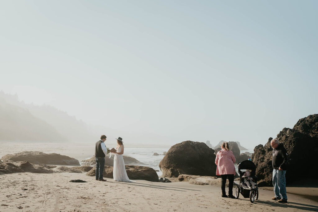 Bride and groom exchange vows during intimate beach wedding ceremony