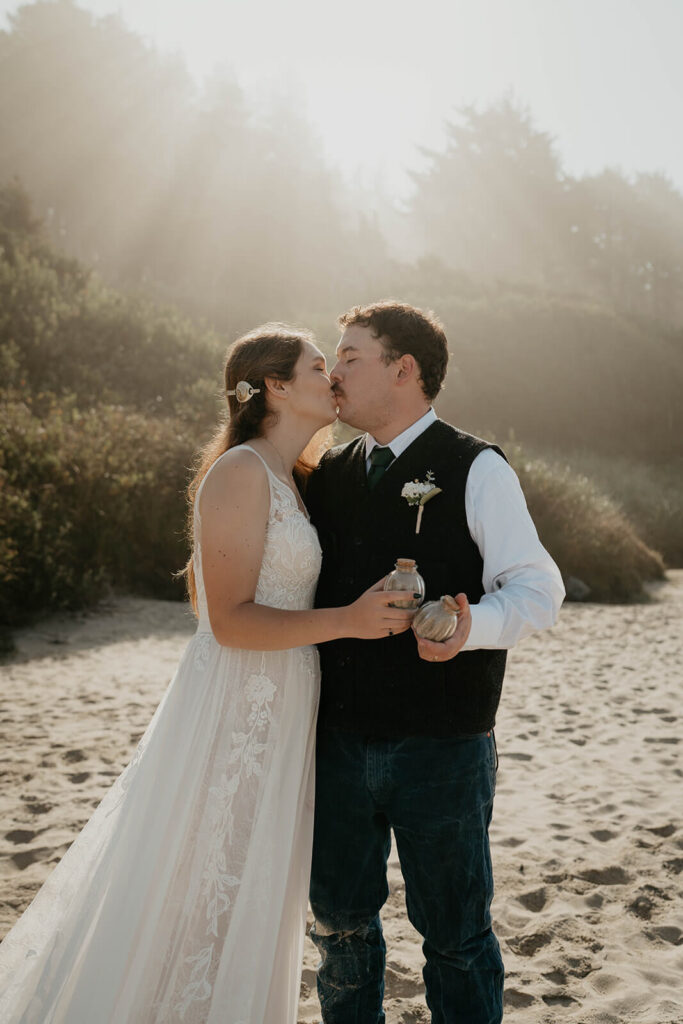 Bride and groom collect sand from their intimate beach wedding on the Oregon Coast