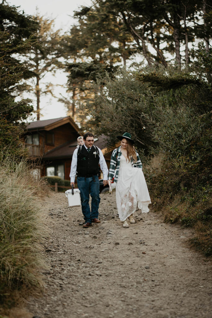 Bride and groom walk down to the beach with their daughter