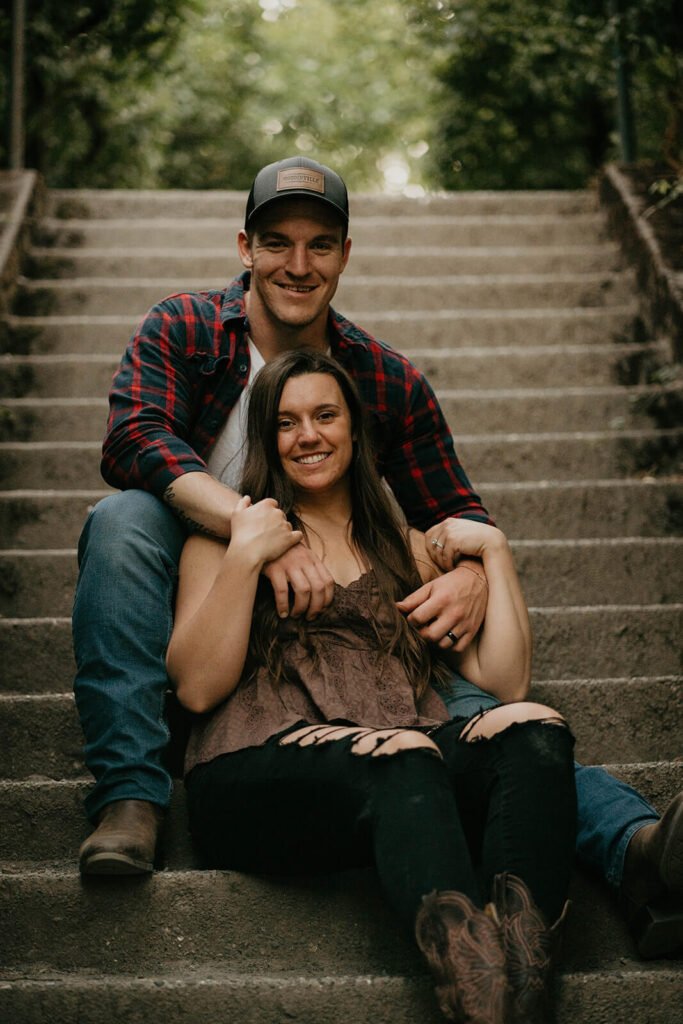 Couple sitting on the steps at Discovery Park during their Seattle engagement photos