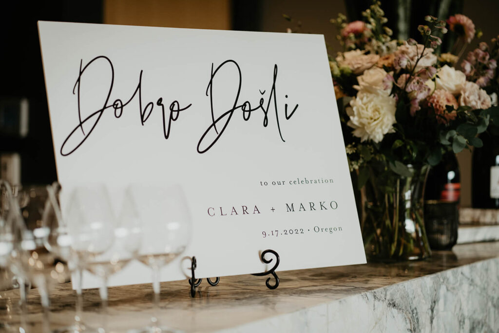 White reception welcome sign at Oregon vineyard wedding