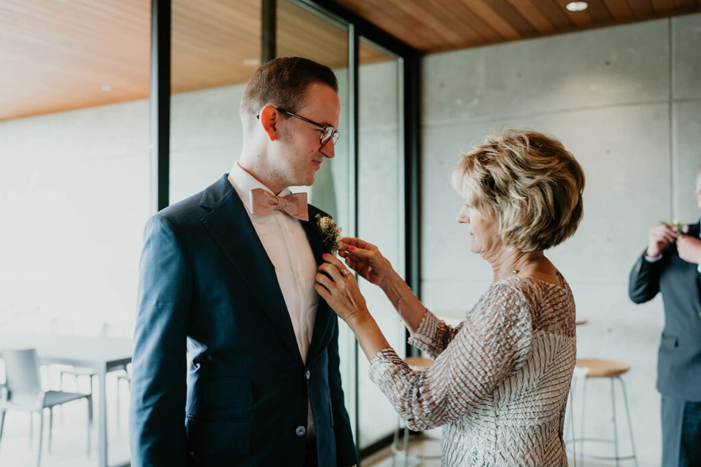 Groom's mother helping him get ready for Oregon vineyard wedding