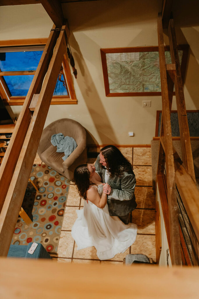 Two brides dancing in their winter wonderland cabin at Mt Hood