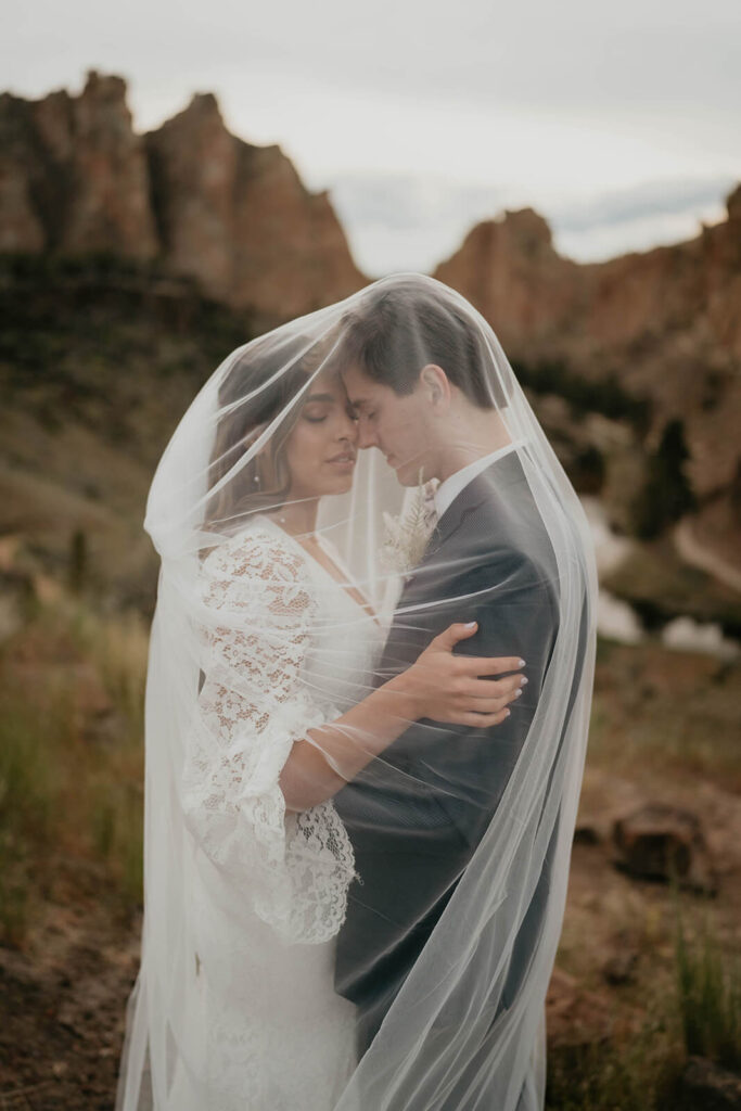 Bride and groom elopement portraits under the wedding veil at Smith Rock elopement