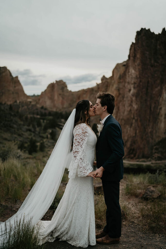 Bride and groom kissing at rock climbing elopement at Smith Rock