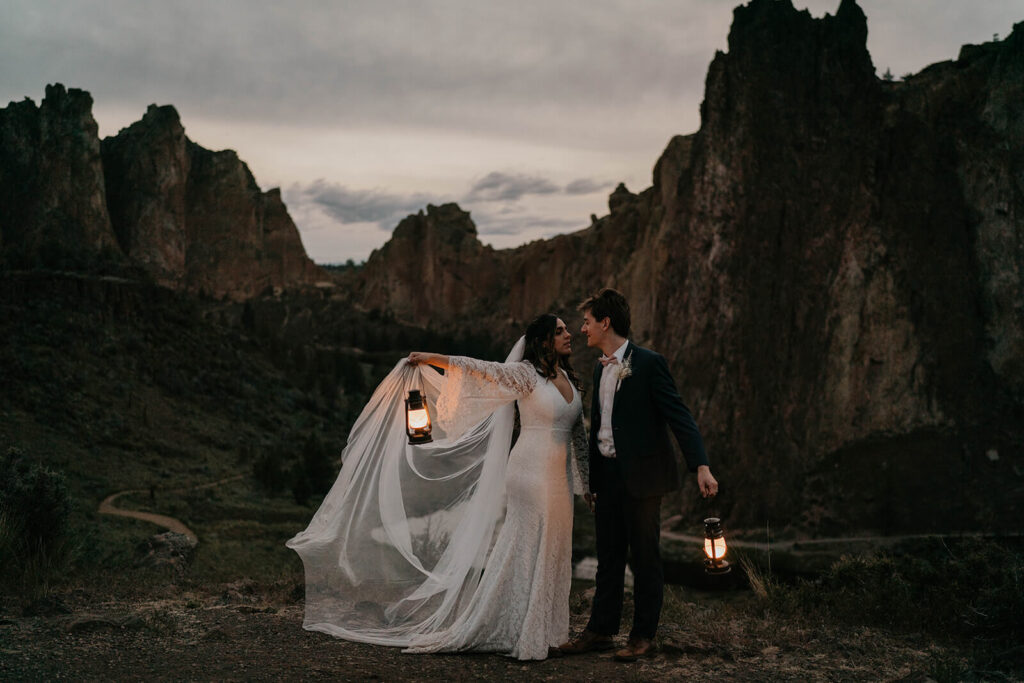 Bride and groom carrying lanterns at their adventure elopement at Smith Rock State Park