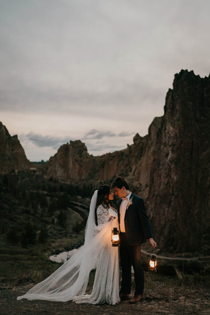 Bride and groom carrying lanterns at their adventure elopement at Smith Rock State Park