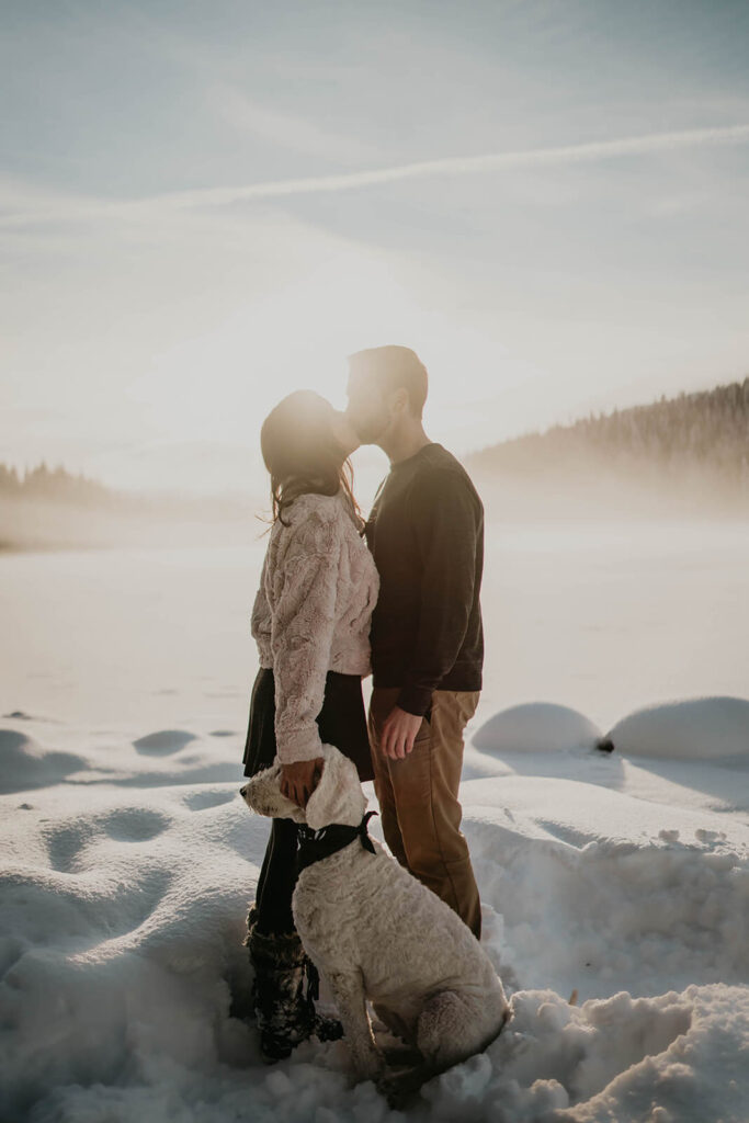 Couple kissing during snowy engagement photos in Oregon